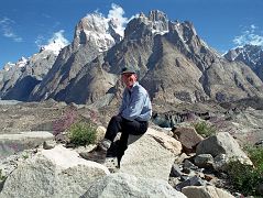 
Jerome Ryan Poses Above Lake On Baltoro Glacier With Great Trango Tower And Trango Castle Behind
